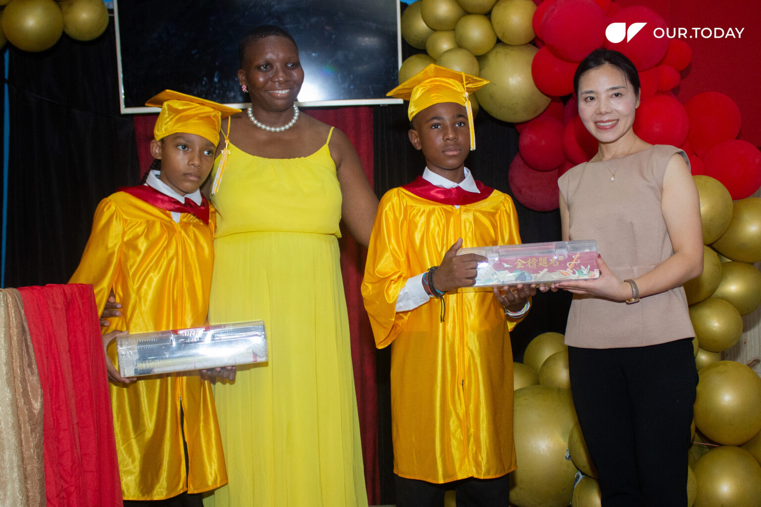 Graduates Shmu’El Holtz and Andre Wynter, along with principal of the Earnest Institute for the Gifted, Hyperactive and Talented Natasha Russell and Chinese Charge d’Affaires, Yang Xiaorong, at the school’s graduation on Thursday, July 3, 2025 (Photo: Olivia Hutchinson/OUR Today)